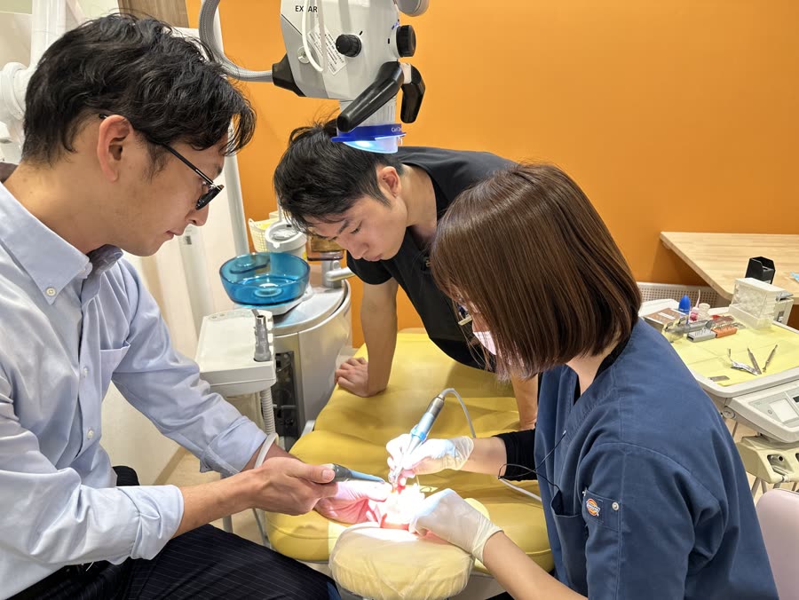 指導歯科医が研修医に手元を見せて教えているところ